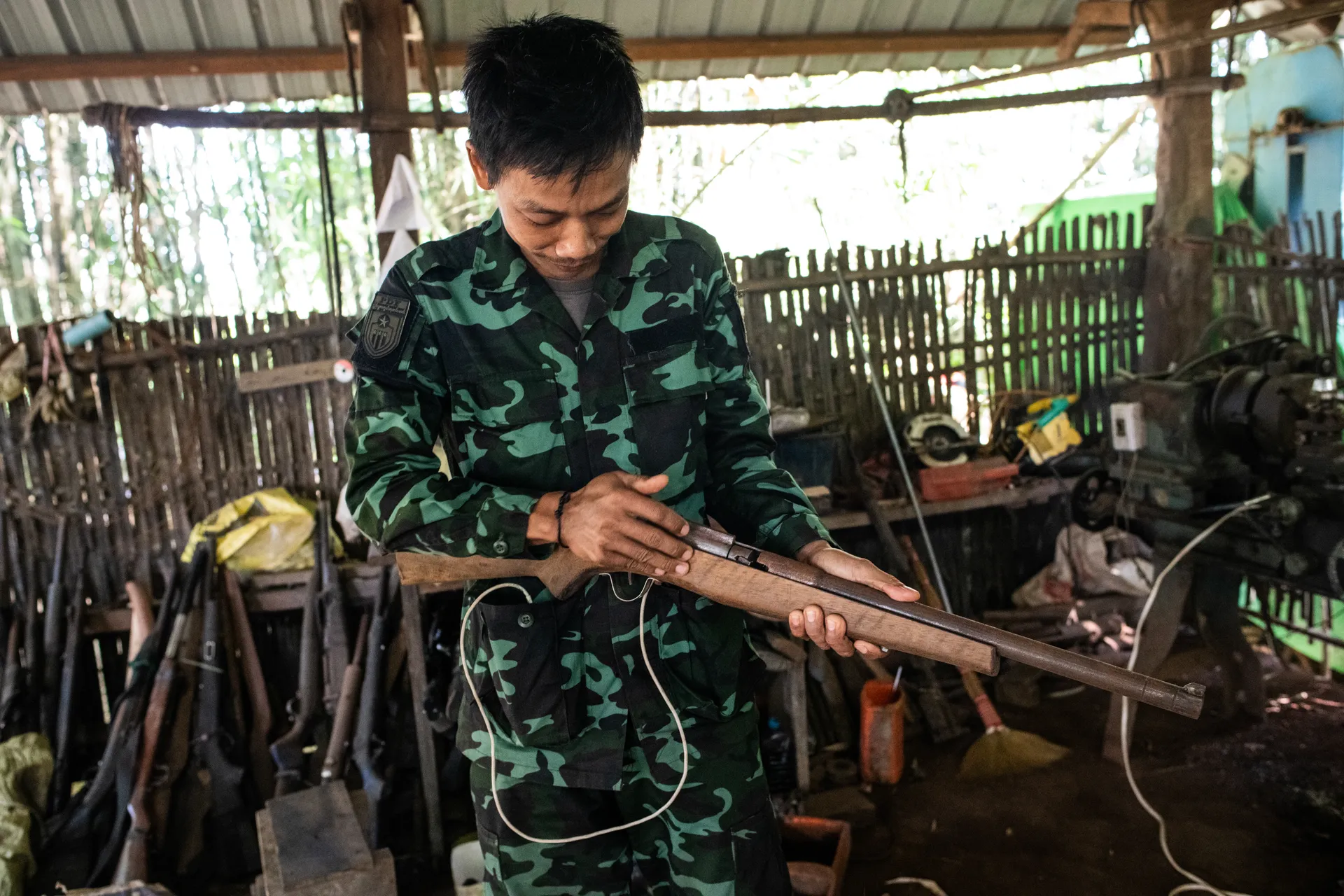 An officer of PDF Battalion 3703 shows off a homemade gun they are using, which can fire a variety of ammo. PDF forces often use homemade guns that can be loaded with ammo to arm new PDF members as they struggle to fight for the revolution. This photo was taken in Nyaunglaypin Township, Bago Region on December 11, 2024. Photo – Mar Naw