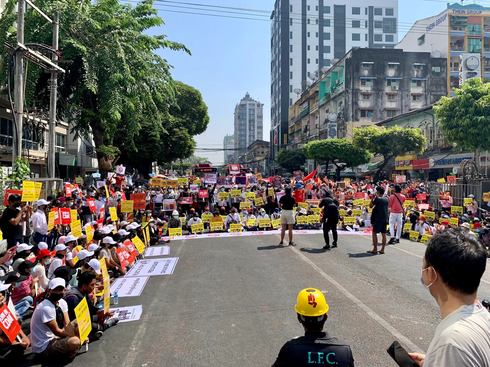 On February 17, 2021, at 11:26 AM, a sit-in protest was observed at the intersection of Bogyoke Pagoda Road and Anawrahta Road in Yangon, where people had gathered. The protesters were actively engaging in the demonstration while expressing their demands.